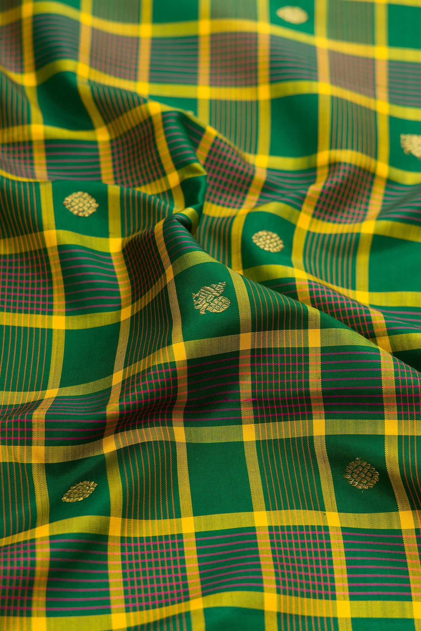 Close up of Green Kanjivaram Silk Saree with Checked design on the body and Zari Border.  displaying folds