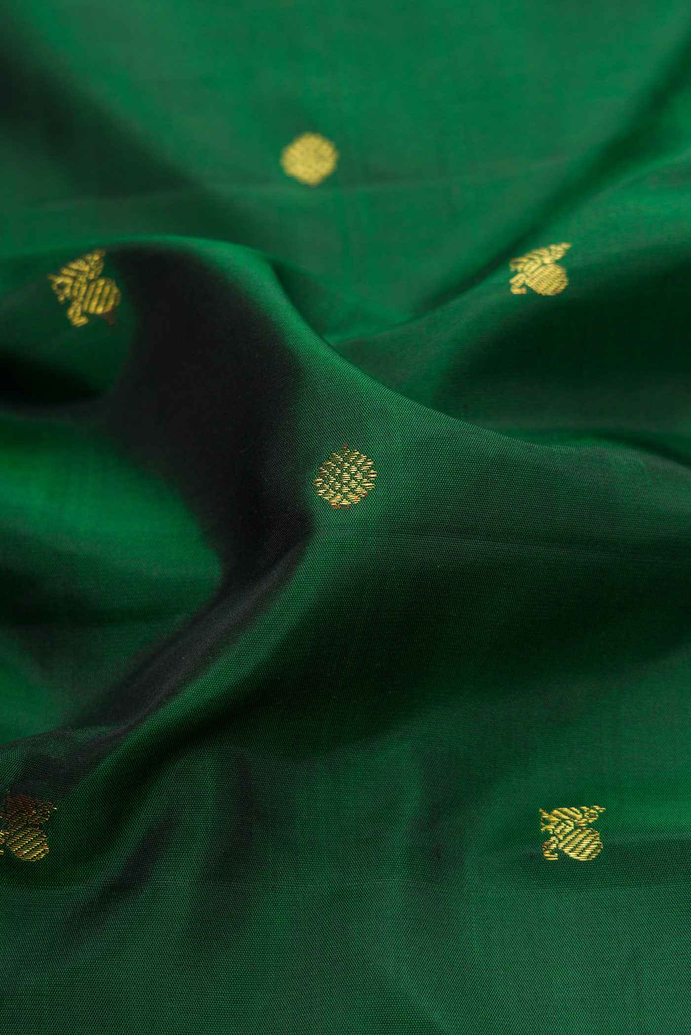 Close up of Pure Silk Pure Zari Green Dual Tone Kanjivaram Saree with Zari Butta on the body and Zari Border.  displaying folds