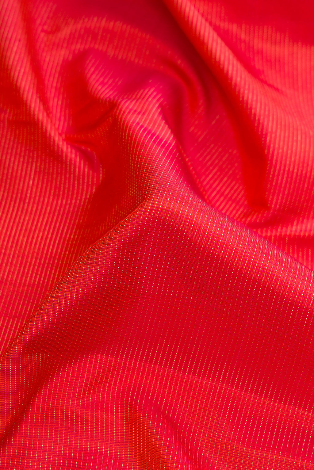 Close up of Brick Orange Dual Tone Kanjivaram Silk Saree with Stripes on the body and Checks Border.  displaying folds