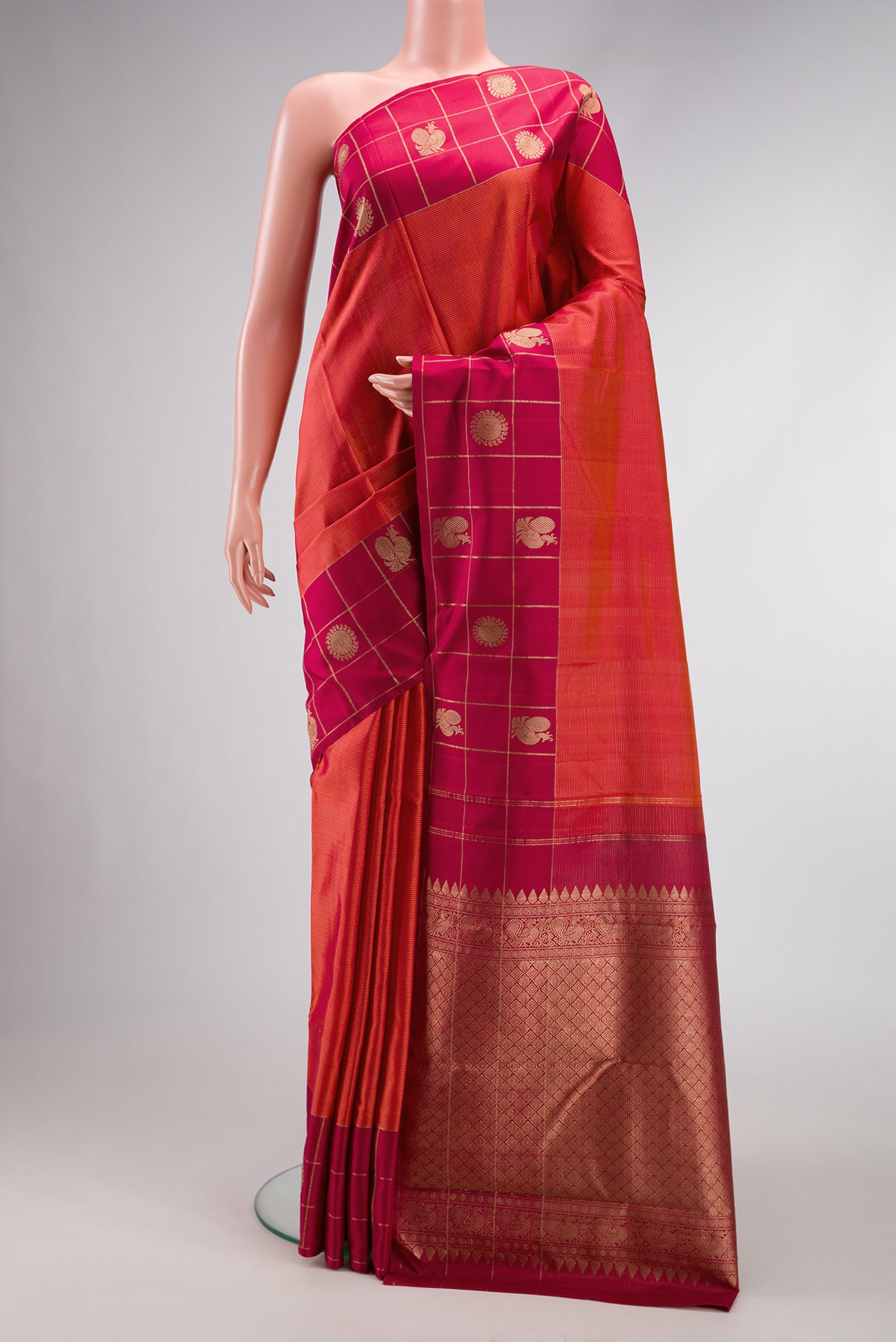 Brick Orange Dual Tone Kanjivaram Silk Saree with Stripes on the body and Checks Border.  displayed on a mannequin