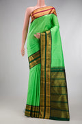 Parrot Green Kanjivaram Silk Saree with Stripes on the body and Ganga Jamuna Border.  displayed on a mannequin