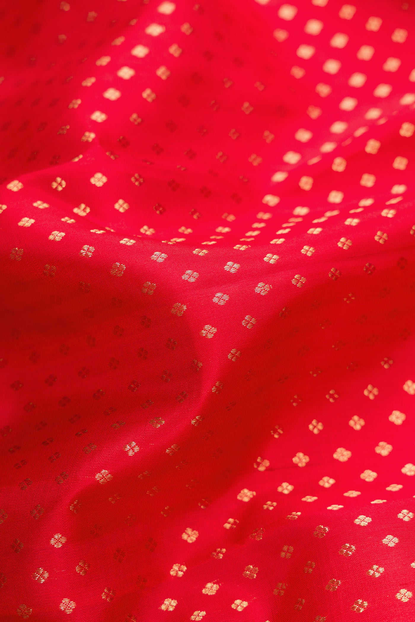 Close up of Pure Silk Pure Zari Red Dual Tone Kanjivaram Saree with Zari Butta on the body and Zari Border.  displaying folds