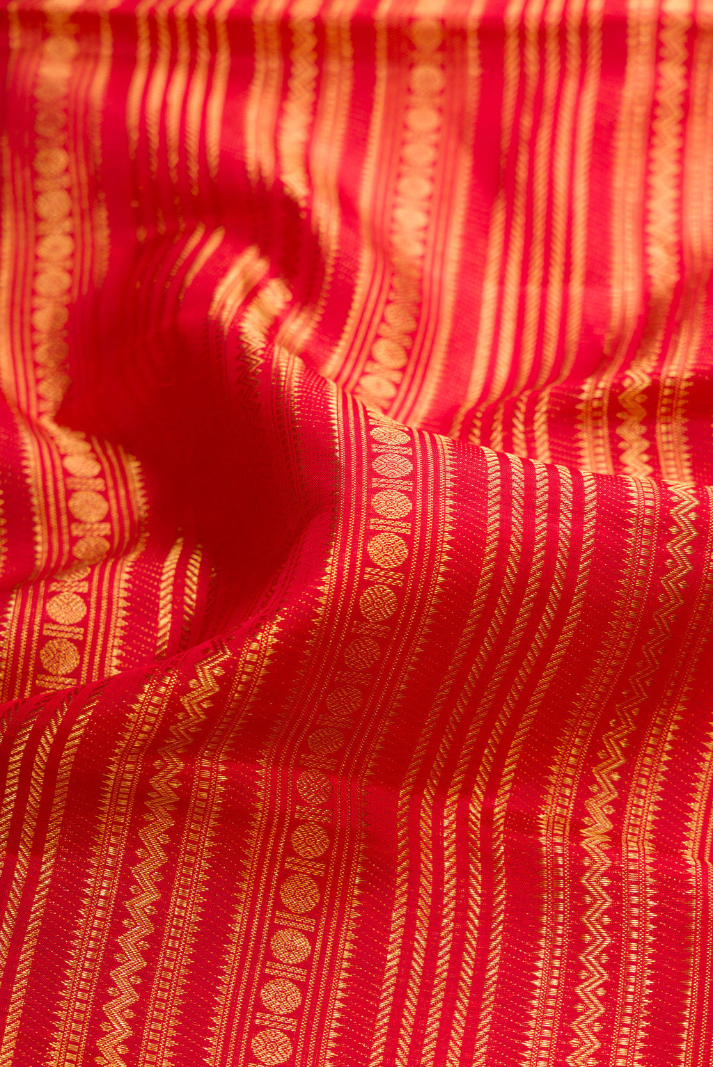 Close up of Red Dual Tone Kanchipuram Silk Saree with Zari Brocade on the body and Fancy Border.  displaying folds