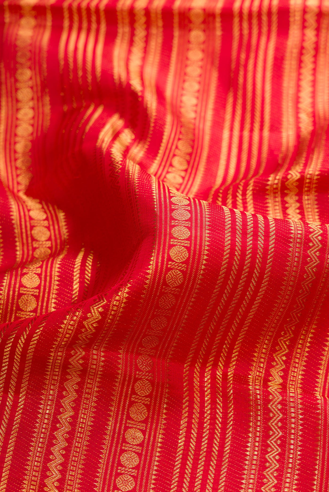 Close up of Red Dual Tone Kanchipuram Silk Saree with Zari Brocade on the body and Fancy Border.  displaying folds