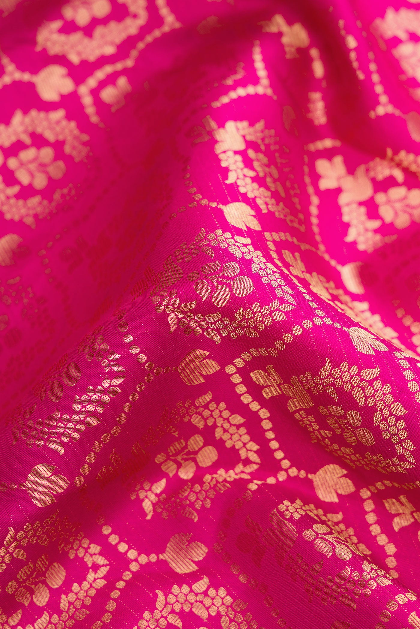 Close up of Magenta Dual Tone Kanjivaram Silk Saree with Zari Brocade on the body and Zari Border.  displaying folds