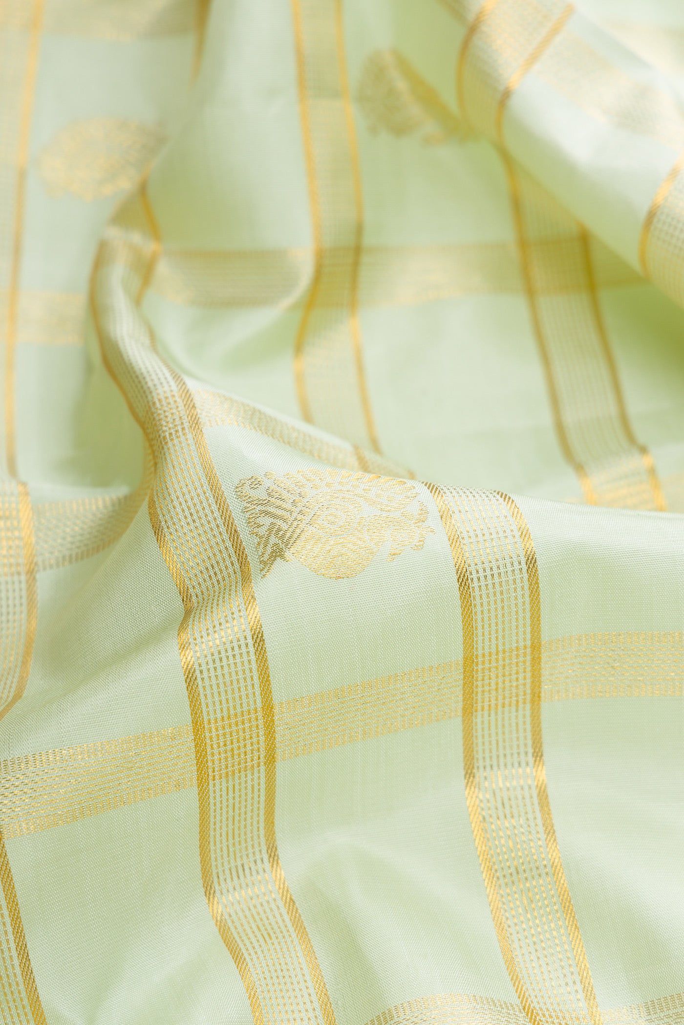 Close up of Pista Green Dual Tone Kanchipuram Silk Saree with Checked design on the body and Zari Border.  displaying folds