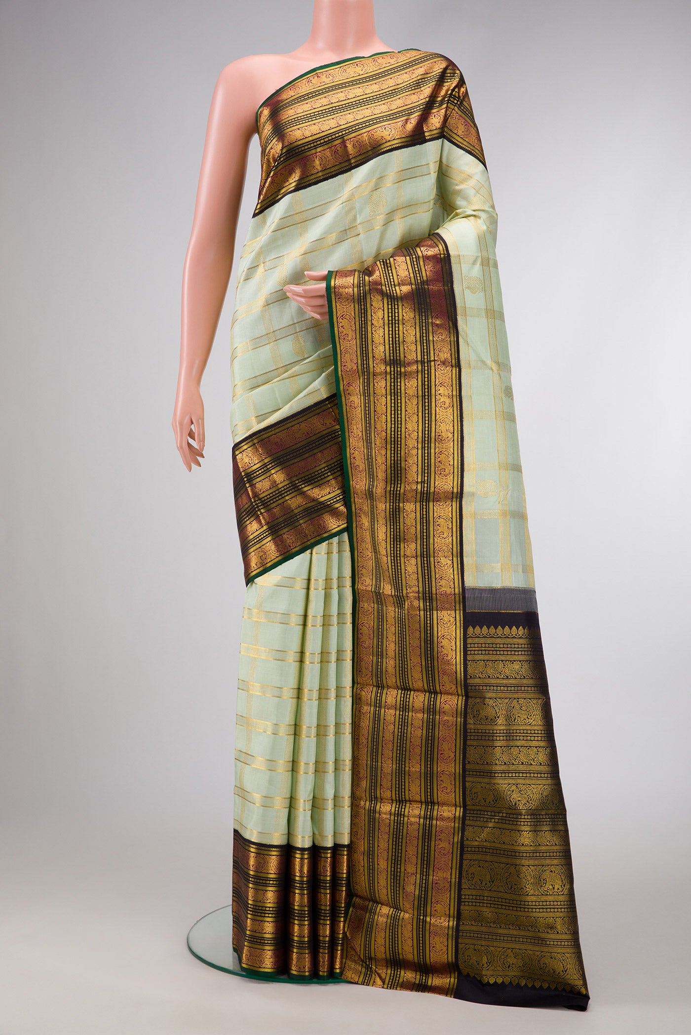 Pista Green Dual Tone Kanchipuram Silk Saree with Checked design on the body and Zari Border.  displayed on a mannequin