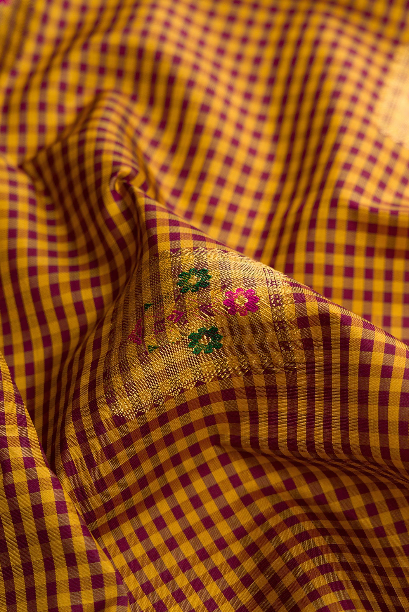Close up of Mustard Dual Tone Kanjivaram Silk Saree with Checked design on the body and Without Border.  displaying folds