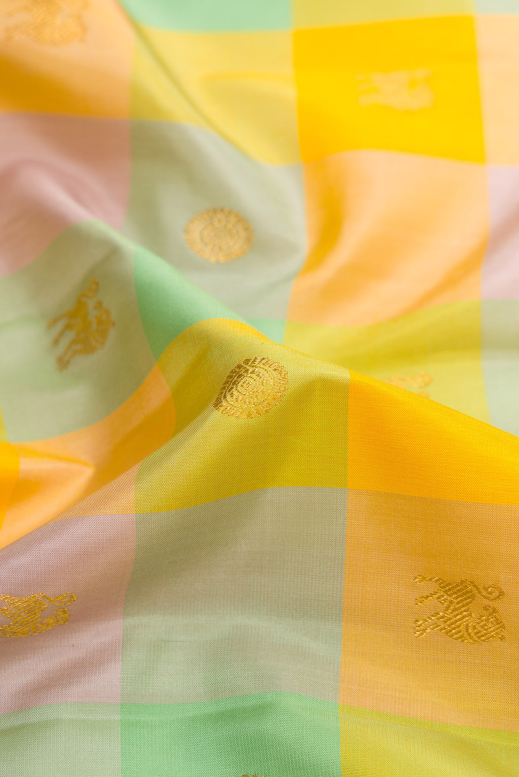 Close up of Yellow , Green and Lilac Color Kanchipuram Silk Saree with Checked design on the body and Zari Border.  displaying folds