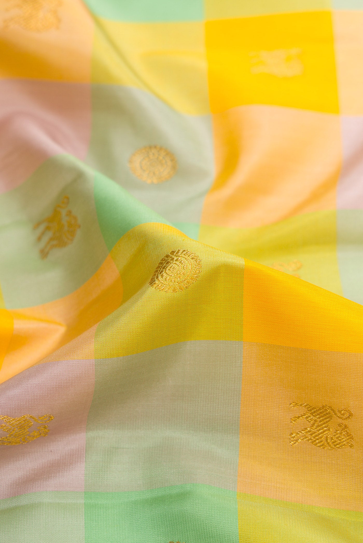Close up of Yellow , Green and Lilac Color Kanchipuram Silk Saree with Checked design on the body and Zari Border.  displaying folds