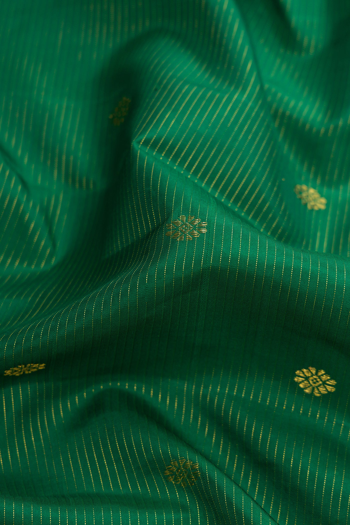 Close up of Pure Silk Pure Zari Green Dual Tone Kanjivaram Saree with Zari Butta on the body and Zari Border.  displaying folds