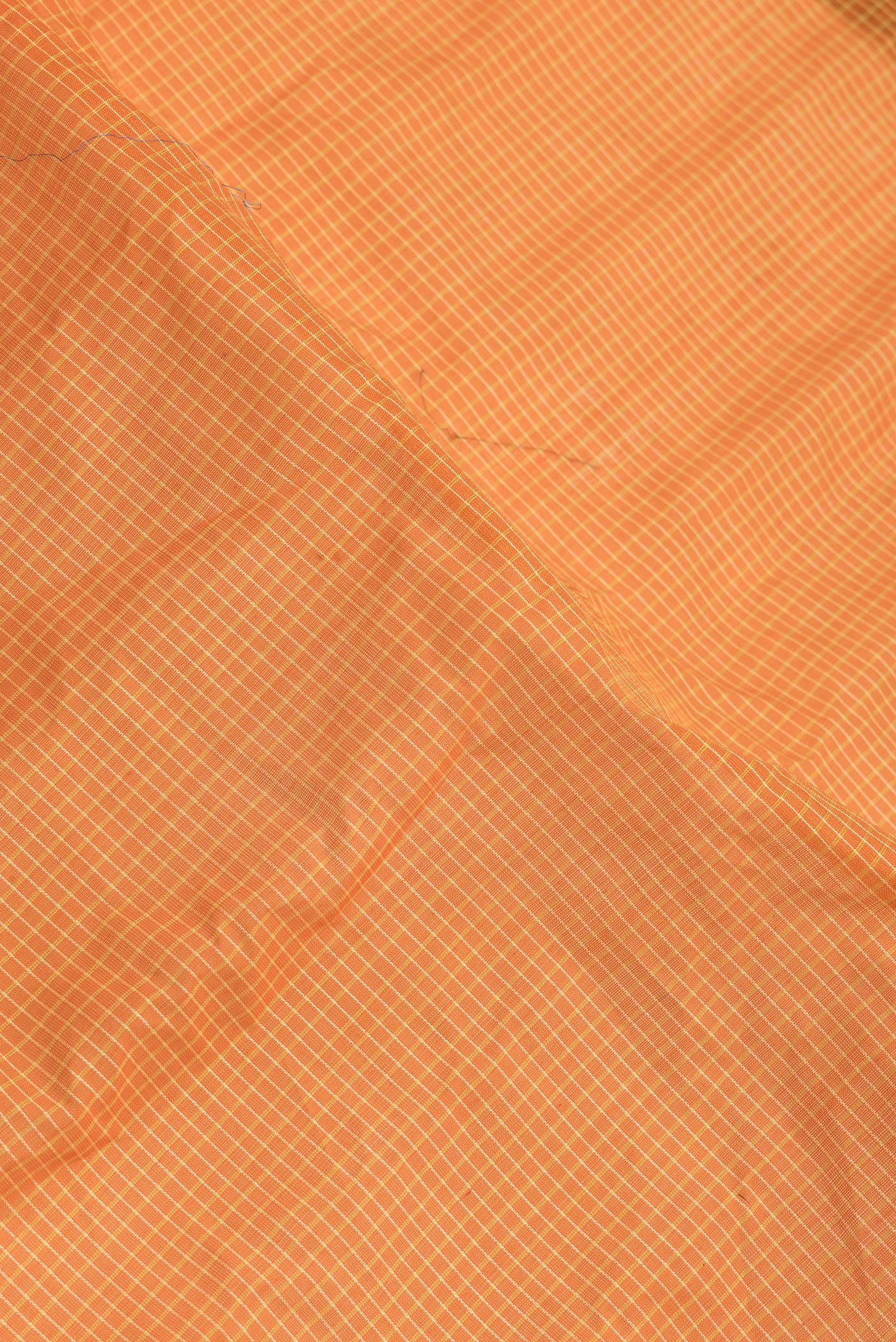 Close up of Orange Dual Tone Gadwal Silk Saree with Checked design on the body and Zari Border.  displaying folds
