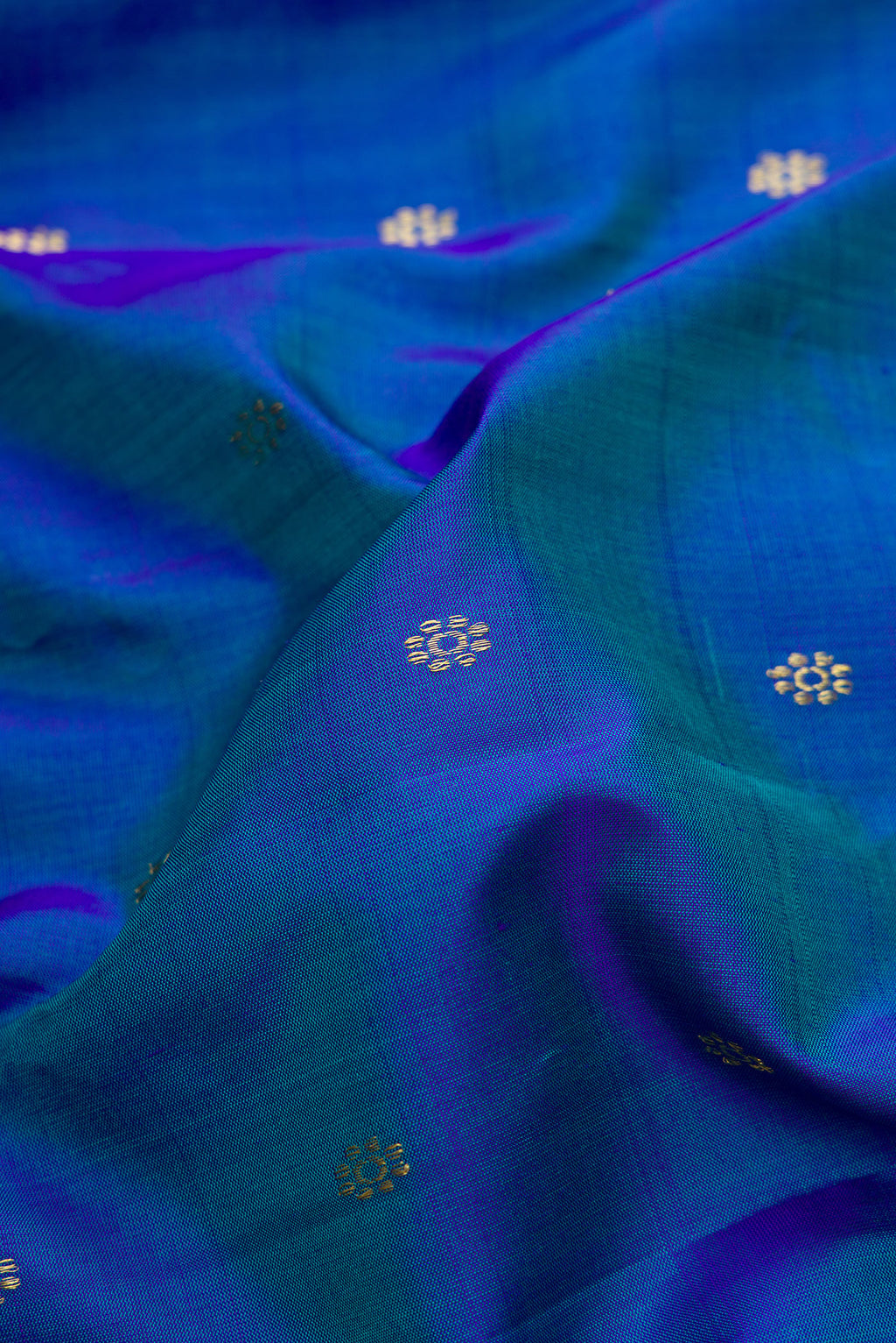 Close up of Peacock Blue Dual Tone Gadwal Silk Saree with Zari Butta on the body and Zari Border.  displaying folds