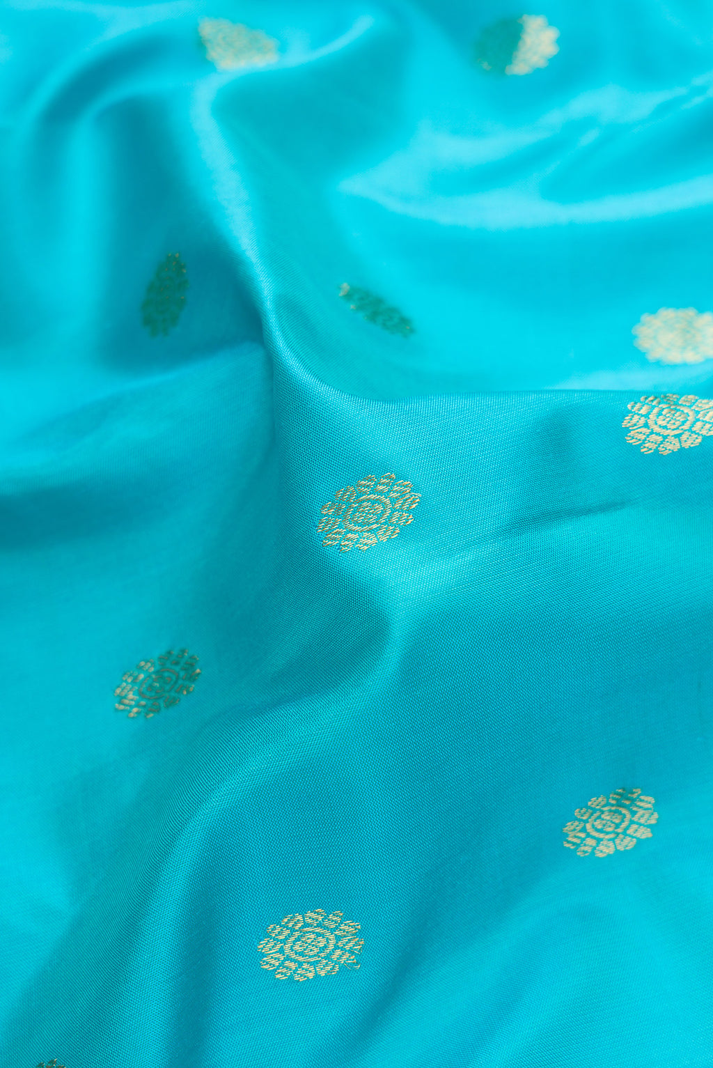 Close up of Sky Blue Dual Tone Gadwal Silk Saree with Zari Butta on the body and Temple Border.  displaying folds
