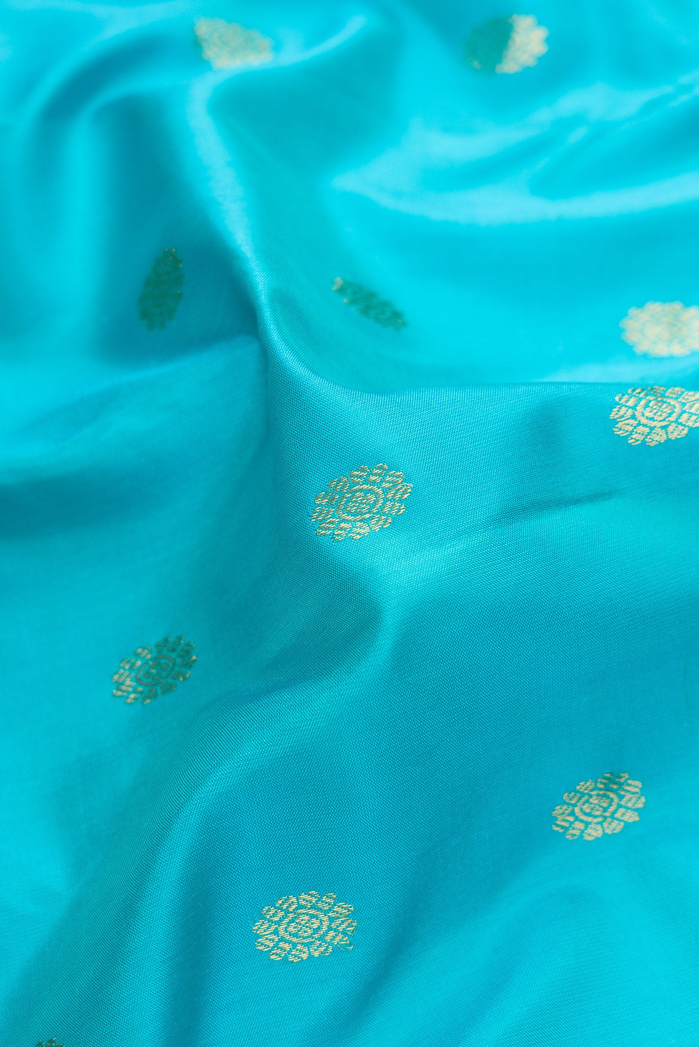 Close up of Sky Blue Dual Tone Gadwal Silk Saree with Zari Butta on the body and Temple Border.  displaying folds