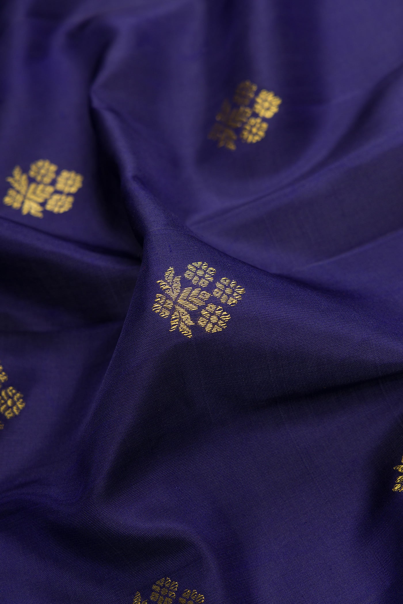 Close up of Navy Blue Dual Tone Gadwal Silk Saree with Zari Butta on the body and Temple Border.  displaying folds