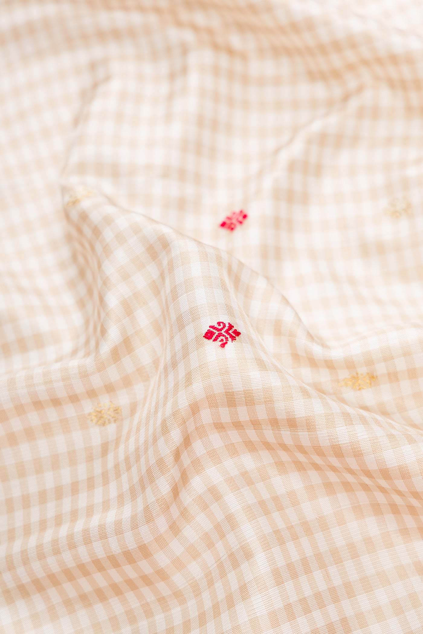Close up of Beige Dual Tone Gadwal Silk Saree with Checked design on the body and Temple Border.  displaying folds