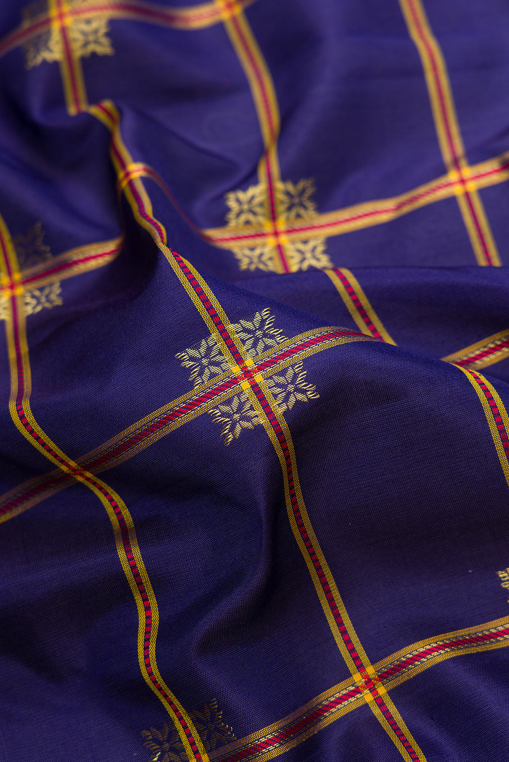 Close up of Navy Blue Dual Tone Gadwal Silk Saree with Checked design on the body and Temple Border.  displaying folds