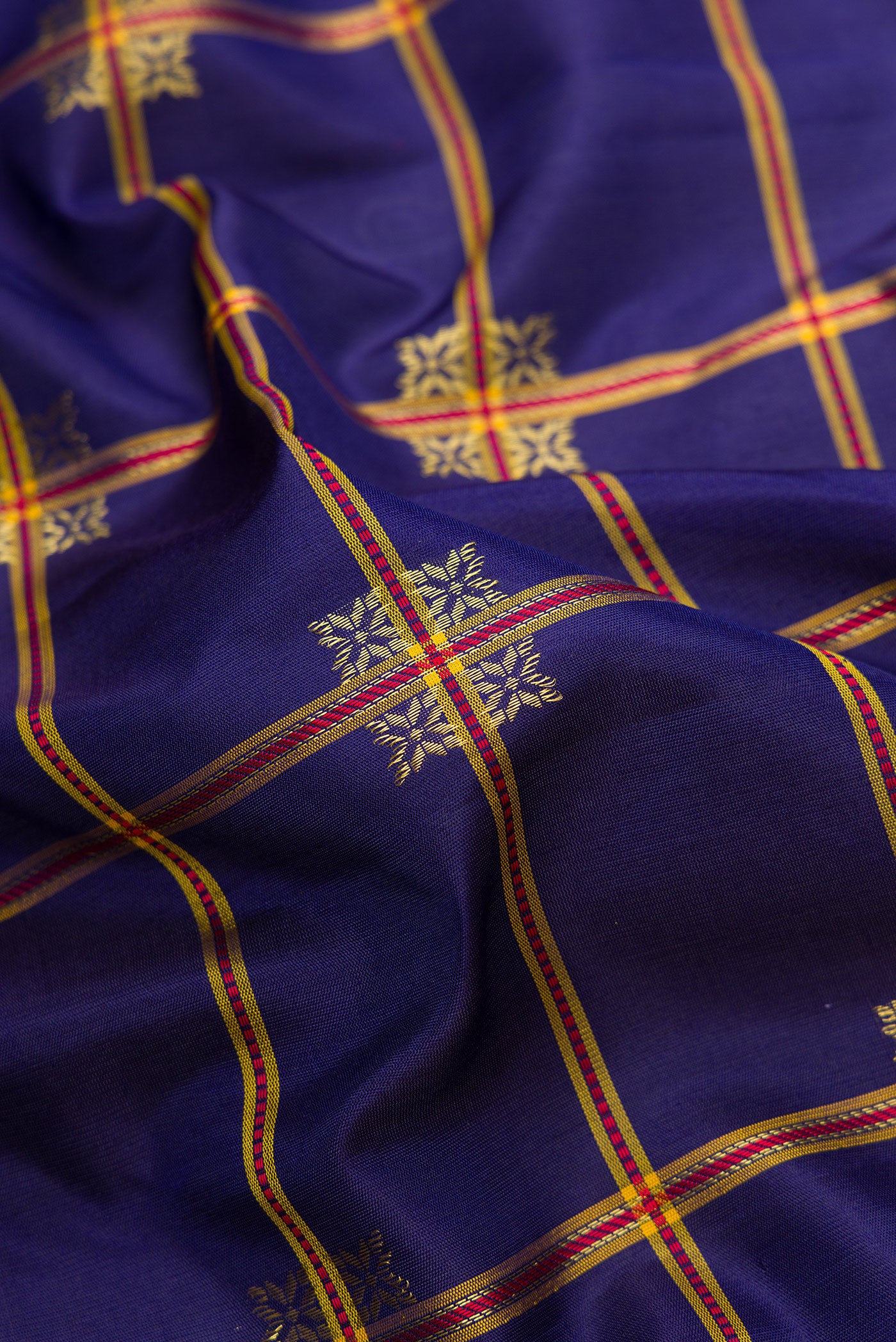 Close up of Navy Blue Dual Tone Gadwal Silk Saree with Checked design on the body and Temple Border.  displaying folds