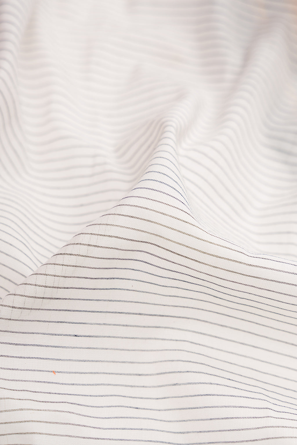 Close up of White Gadwal Silk Cotton Saree with Stripes on the body and Zari Border.  displaying folds