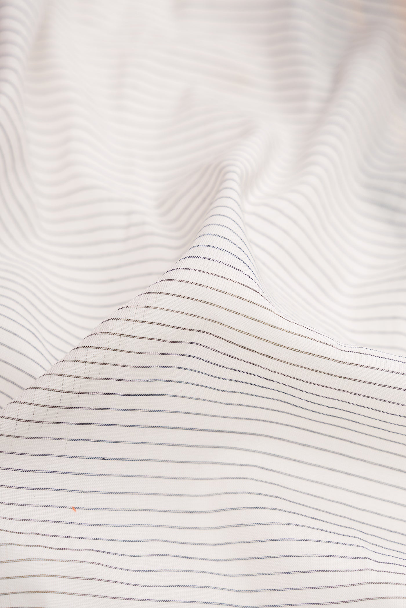 Close up of White Gadwal Silk Cotton Saree with Stripes on the body and Zari Border.  displaying folds