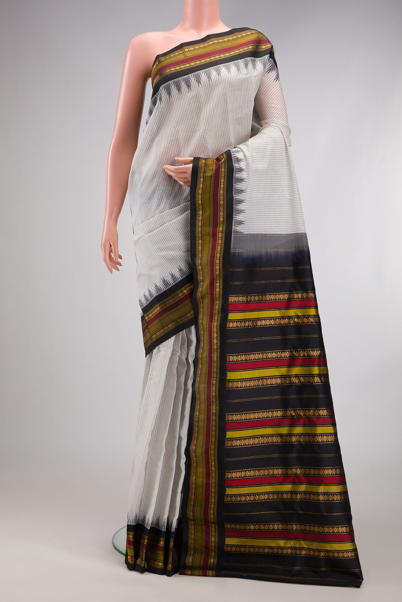 White Gadwal Silk Cotton Saree with Stripes on the body and Zari Border.  displayed on a mannequin