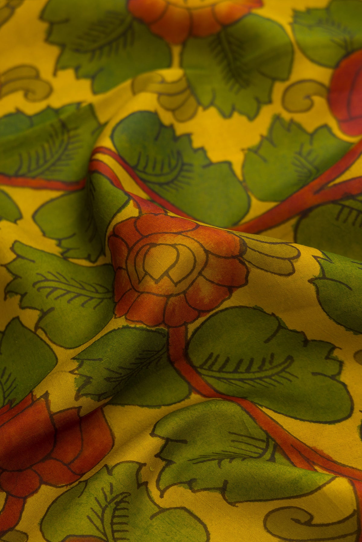 Close up of Mehandi Green Dual Tone Kanchipuram Silk Saree with kalamkari Print on the body and Zari Border.  displaying folds