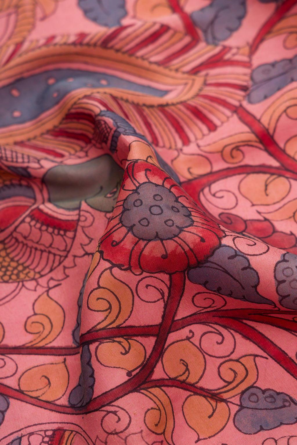 Close up of Rose Gold Dual Tone Kanchipuram Silk Saree with kalamkari Print on the body and Zari Border.  displaying folds