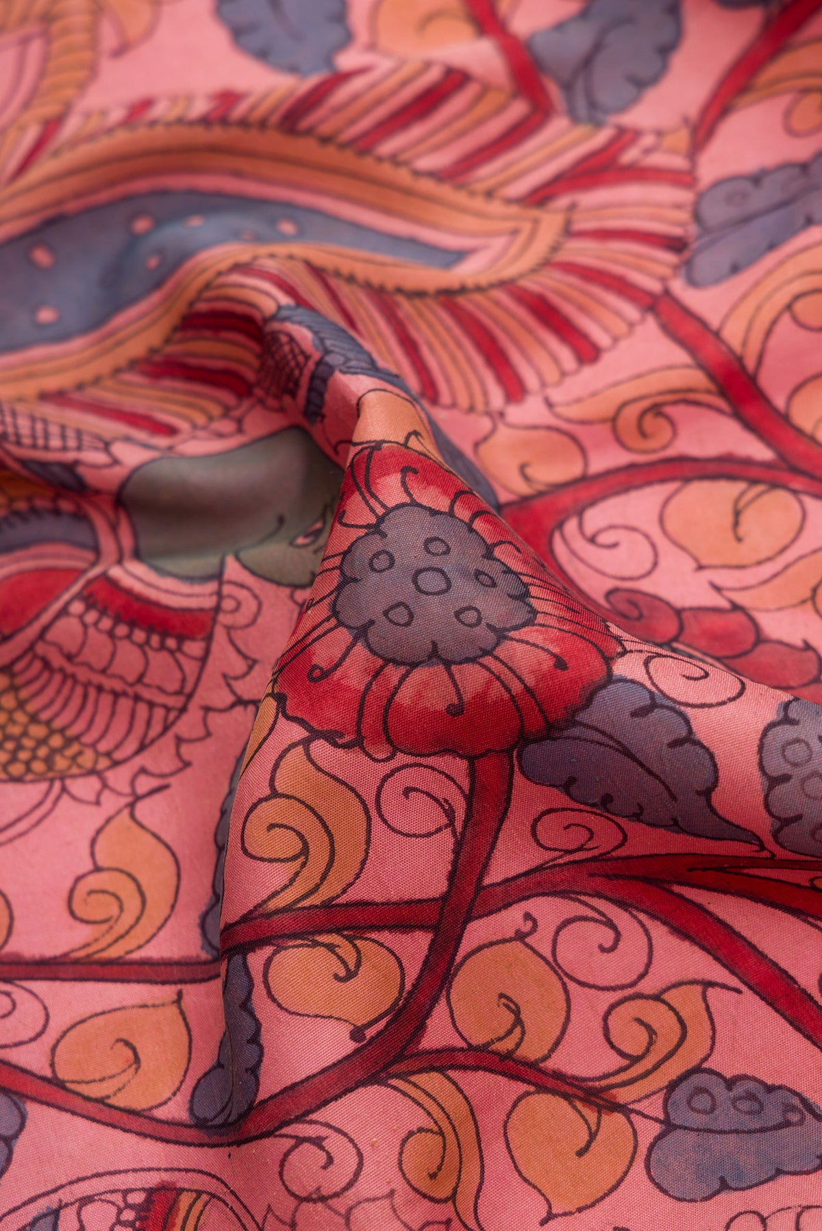 Close up of Rose Gold Dual Tone Kanchipuram Silk Saree with kalamkari Print on the body and Zari Border.  displaying folds