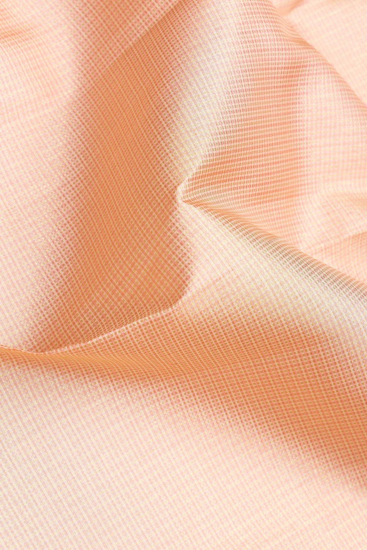 Close up of Golden Peach Dual Tone Kanjivaram Silk Saree with Checked design on the body and Zari Border.  displaying folds