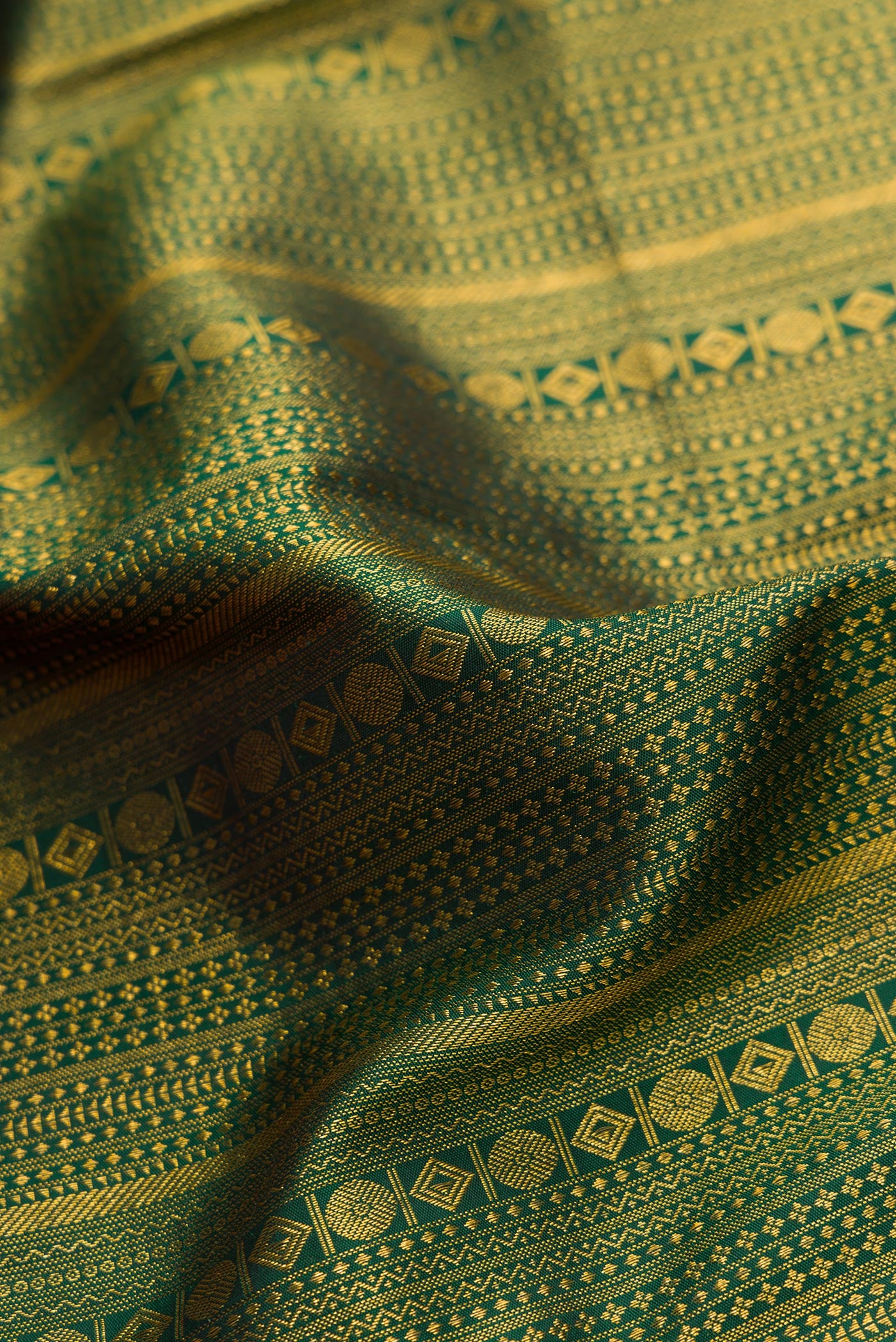 Close up of Bottle Green Dual Tone Kanjivaram Silk Saree with Zari Brocade on the body and Zari Border.  displaying folds