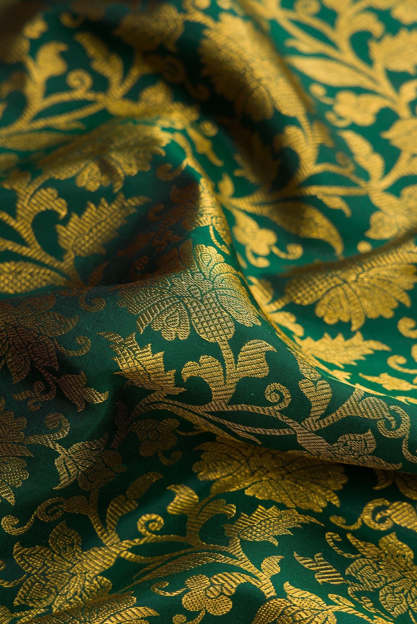 Close up of Bottle Green Dual Tone Kanjivaram Silk Saree with Zari Brocade on the body and Zari Border.  displaying folds