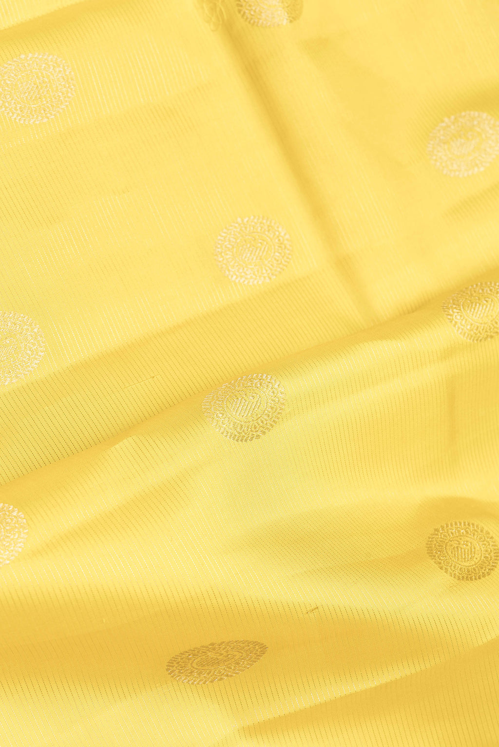 Close up of Yellow Dual Tone Kanchipuram Silk Saree with Zari Butta on the body and Zari Border.  displaying folds