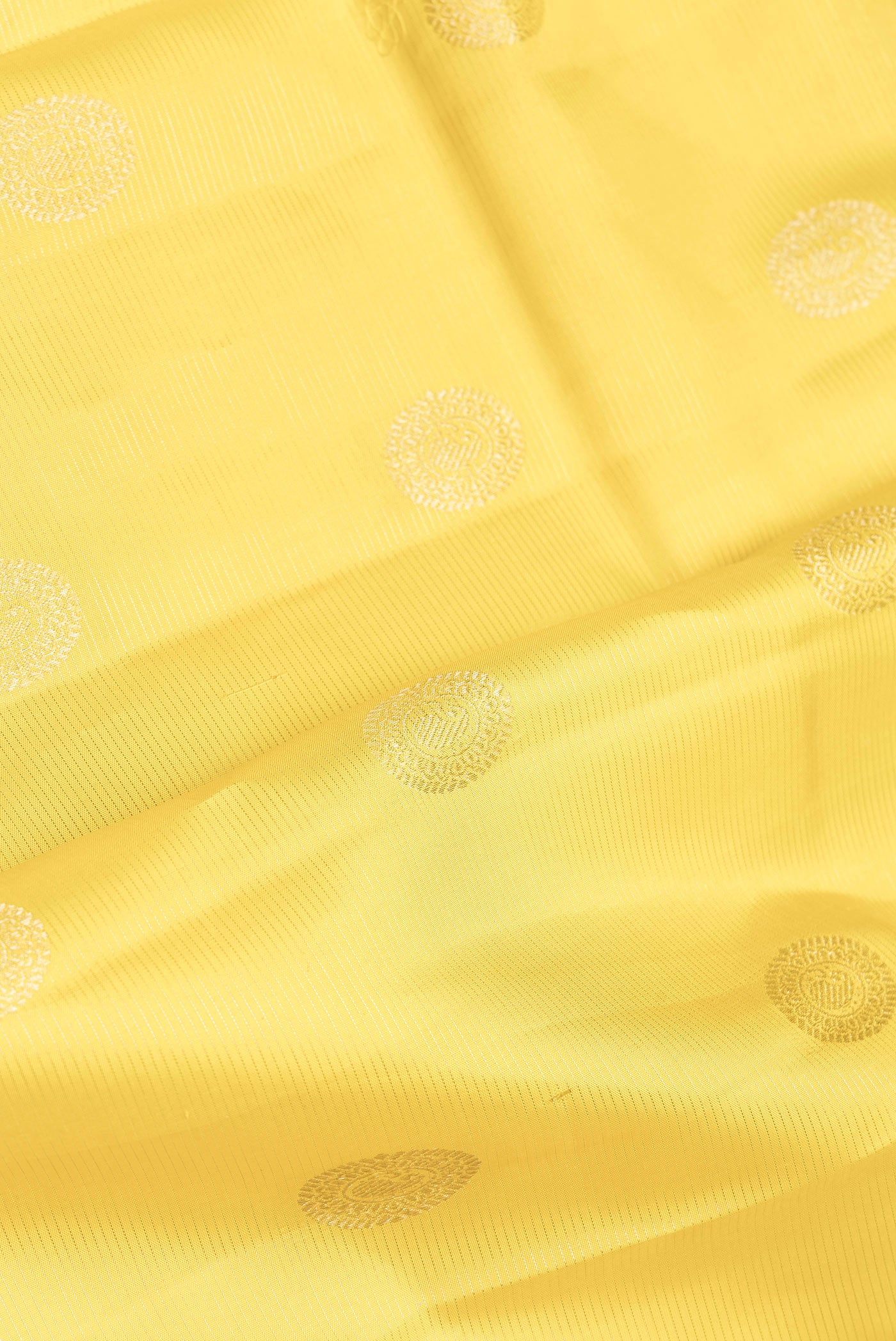 Close up of Yellow Dual Tone Kanchipuram Silk Saree with Zari Butta on the body and Zari Border.  displaying folds