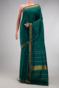 Bottle Green Kanchipuram Silk Saree with Zari Butta on the body and Zari Border.  displayed on a mannequin
