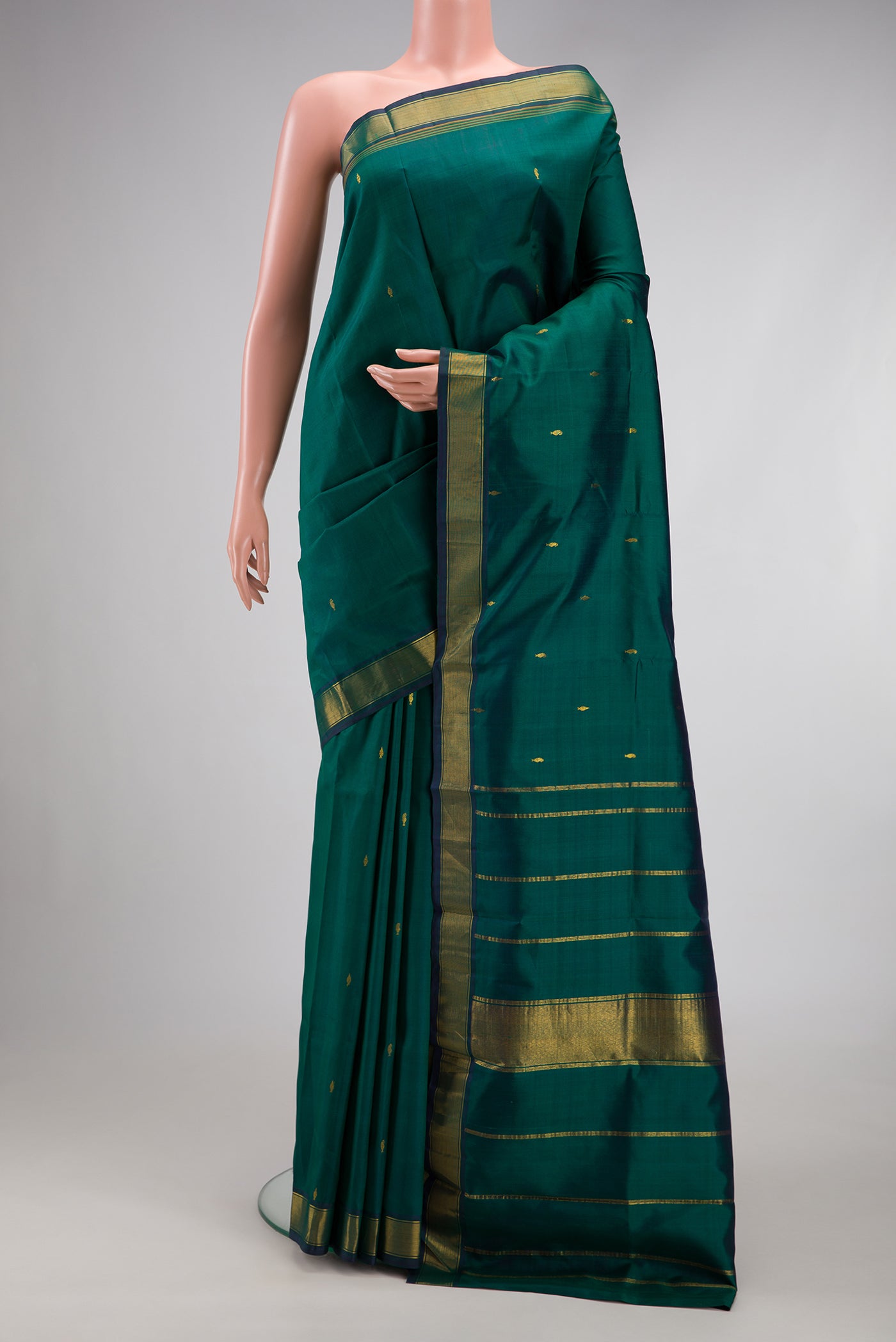 Bottle Green Kanchipuram Silk Saree with Zari Butta on the body and Zari Border.  displayed on a mannequin