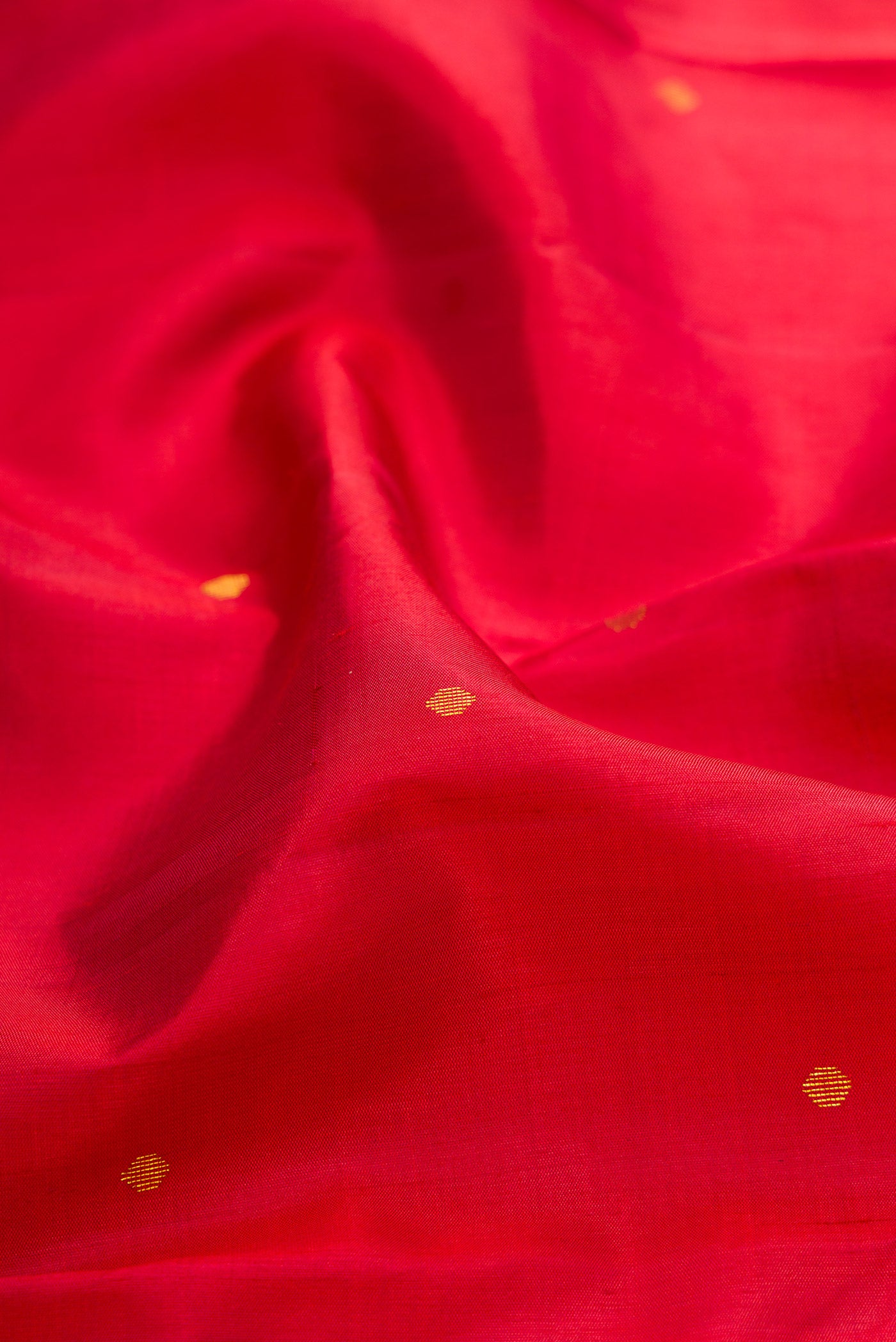 Close up of Red Kanchipuram Silk Saree with Zari Butta on the body and Zari Border.  displaying folds