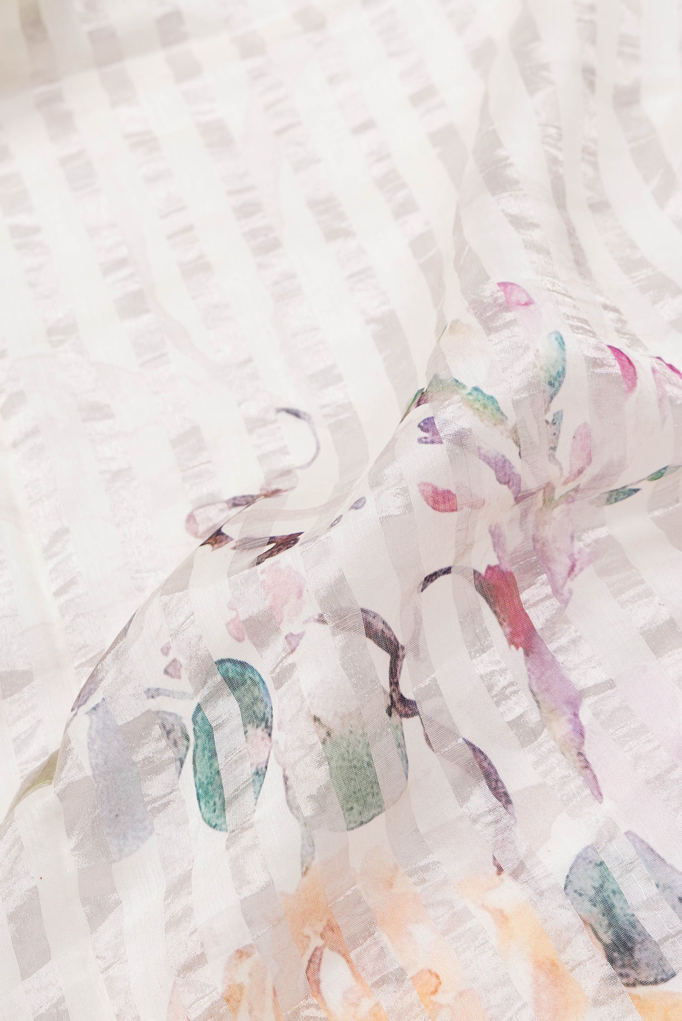 Close up of Beige Dual Tone Organza Silk Saree with Printed design on the body and Without Border.  displaying folds