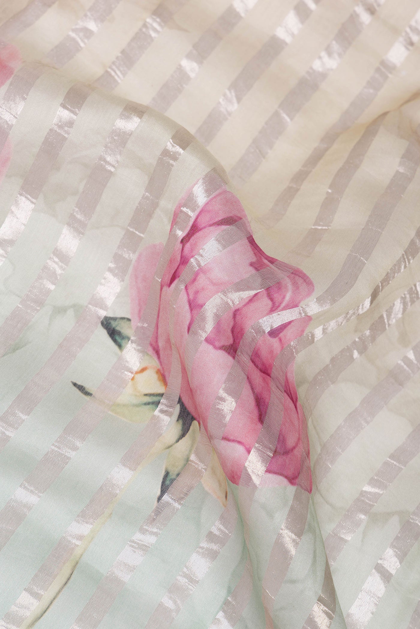 Close up of Beige and Green Color Organza Silk Saree with Stripes on the body and Without Border.  displaying folds
