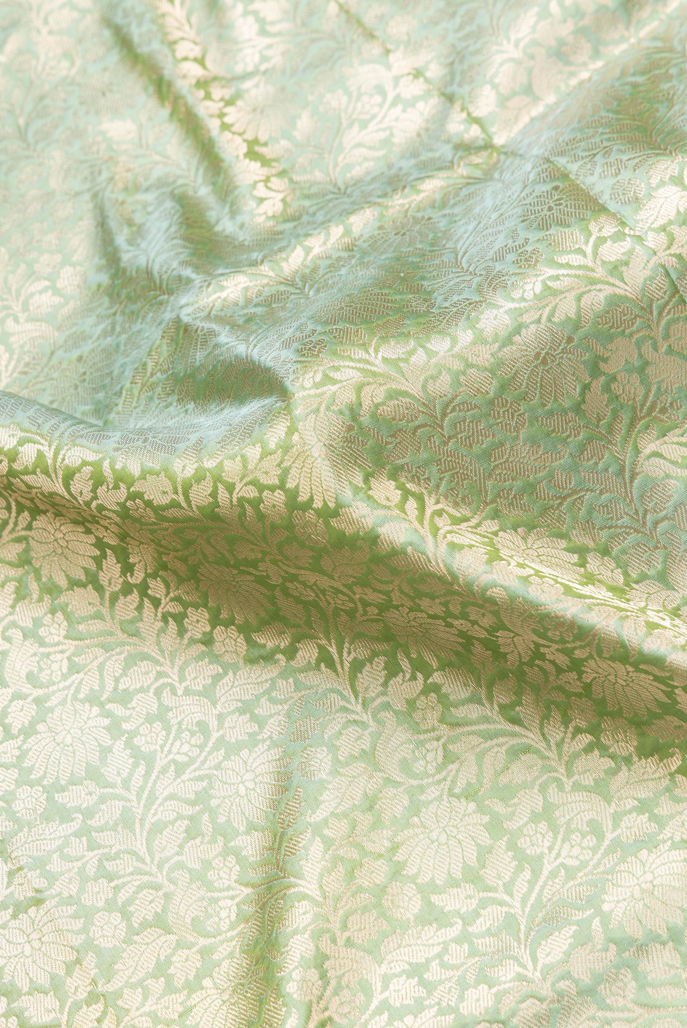 Close up of Sea Green Dual Tone Banarasi Silk Saree with Zari Brocade on the body and Zari Border.  displaying folds