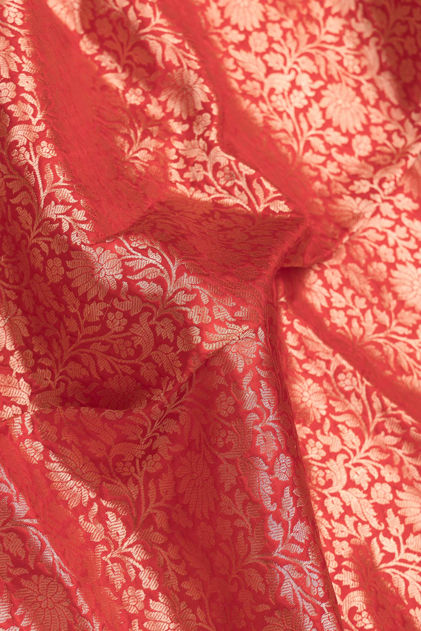 Close up of Red Dual Tone Banarasi Silk Saree with Zari Brocade on the body and Zari Border.  displaying folds