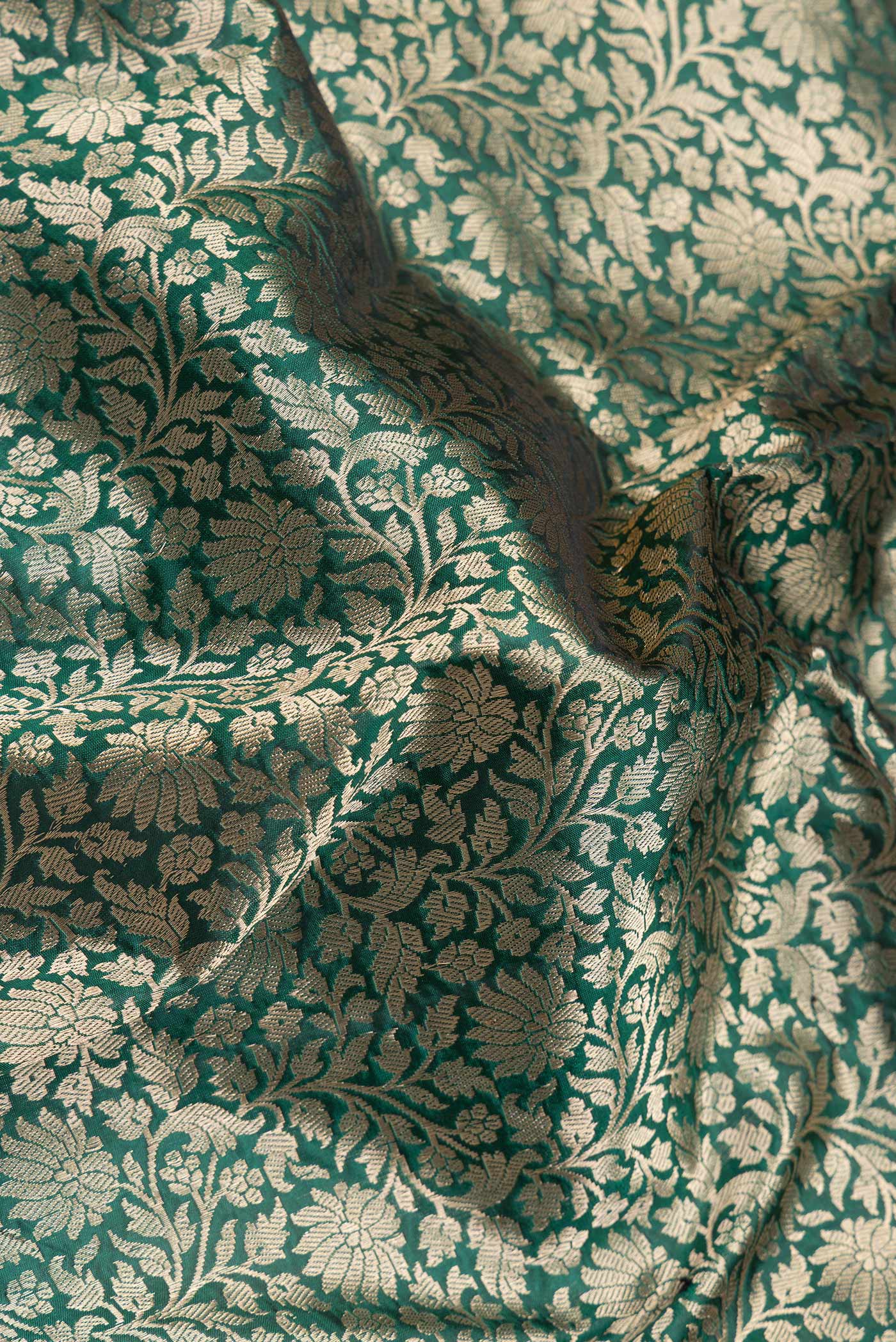 Close up of Green Dual Tone Banarasi Silk Saree with Zari Brocade on the body and Zari Border.  displaying folds