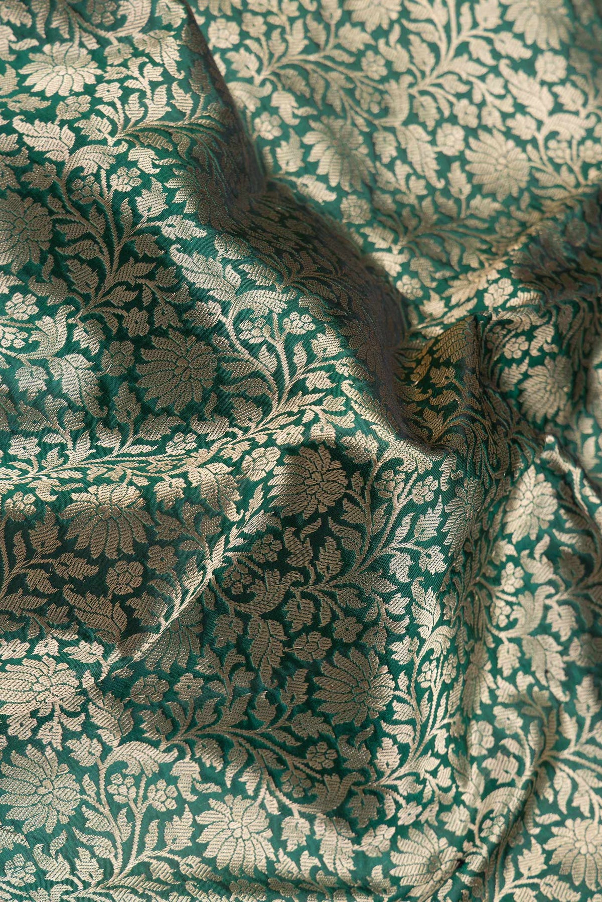 Close up of Green Dual Tone Banarasi Silk Saree with Zari Brocade on the body and Zari Border.  displaying folds