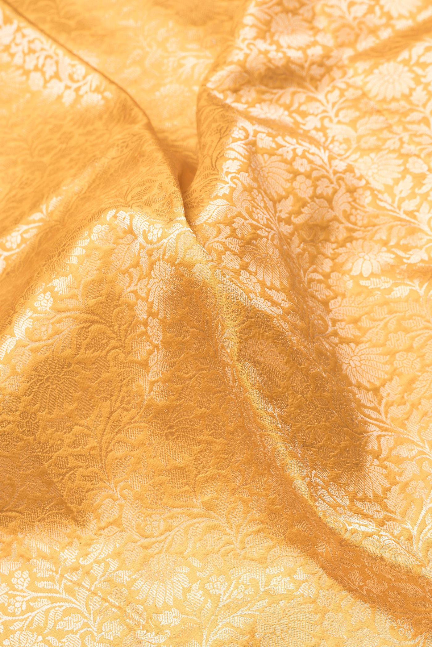 Close up of Mustard Dual Tone Banarasi Silk Saree with Zari Brocade on the body and Zari Border.  displaying folds