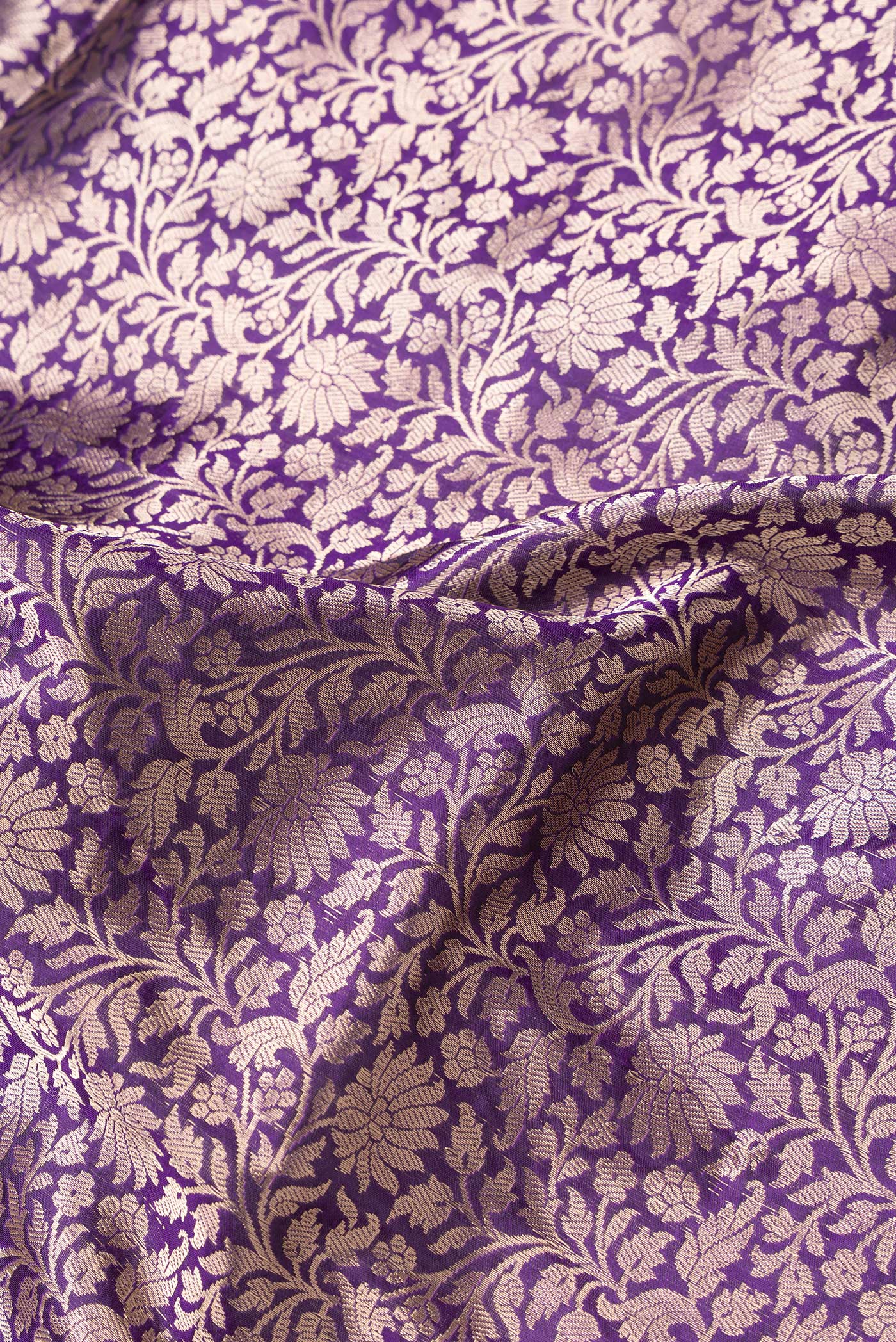 Close up of Violet Dual Tone Banarasi Silk Saree with Zari Brocade on the body and Zari Border.  displaying folds