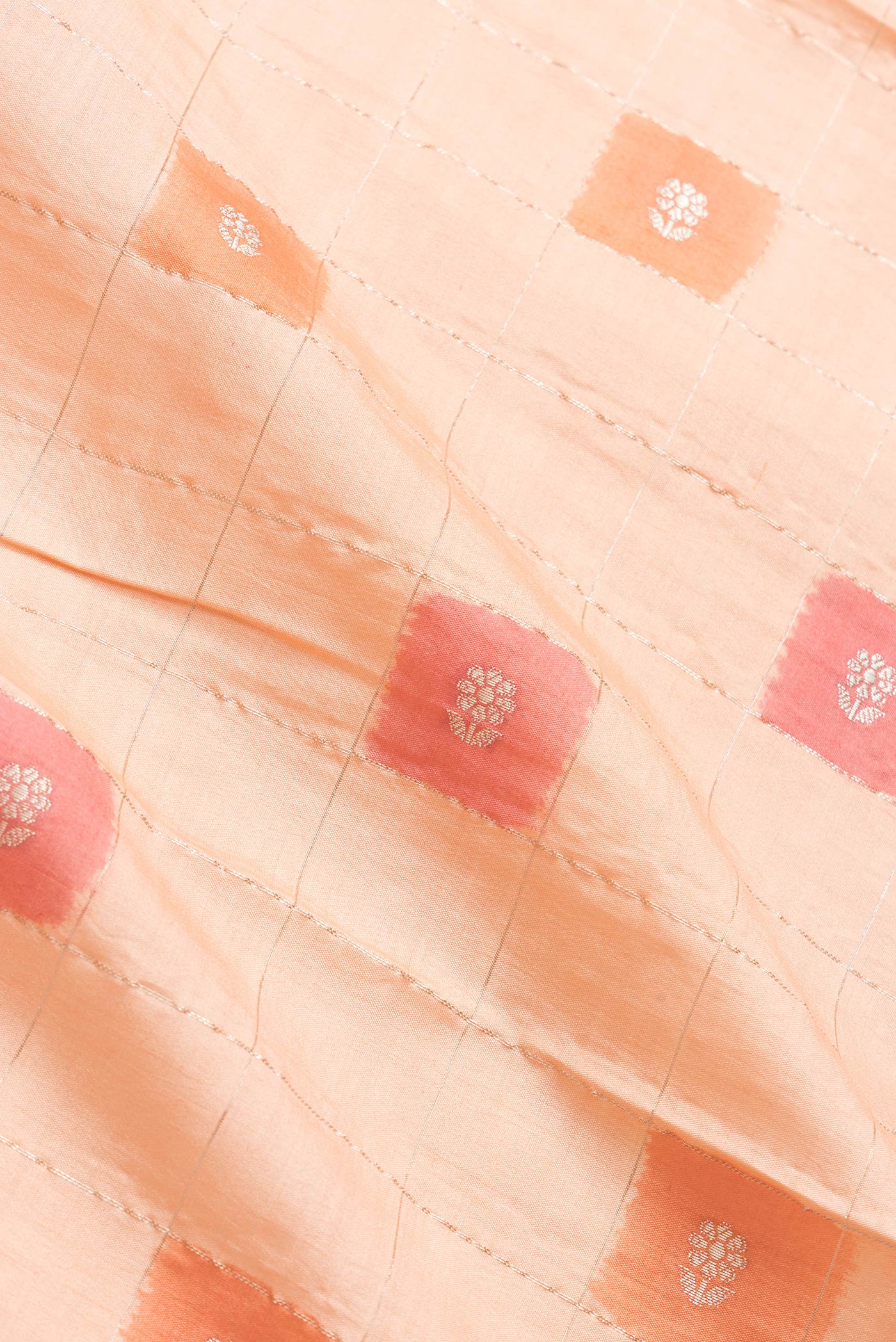 Close up of Peach Dual Tone Tussar Silk Saree with Checked design on the body and Fancy Border.  displaying folds