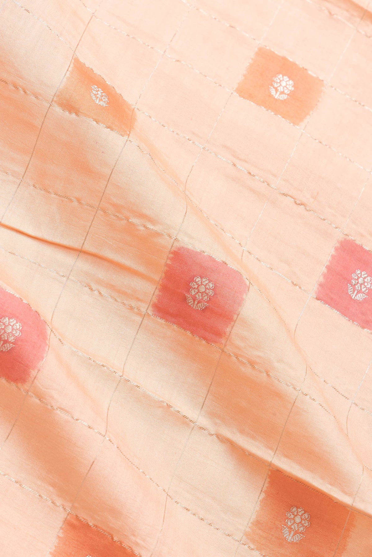 Close up of Peach Dual Tone Tussar Silk Saree with Checked design on the body and Fancy Border.  displaying folds