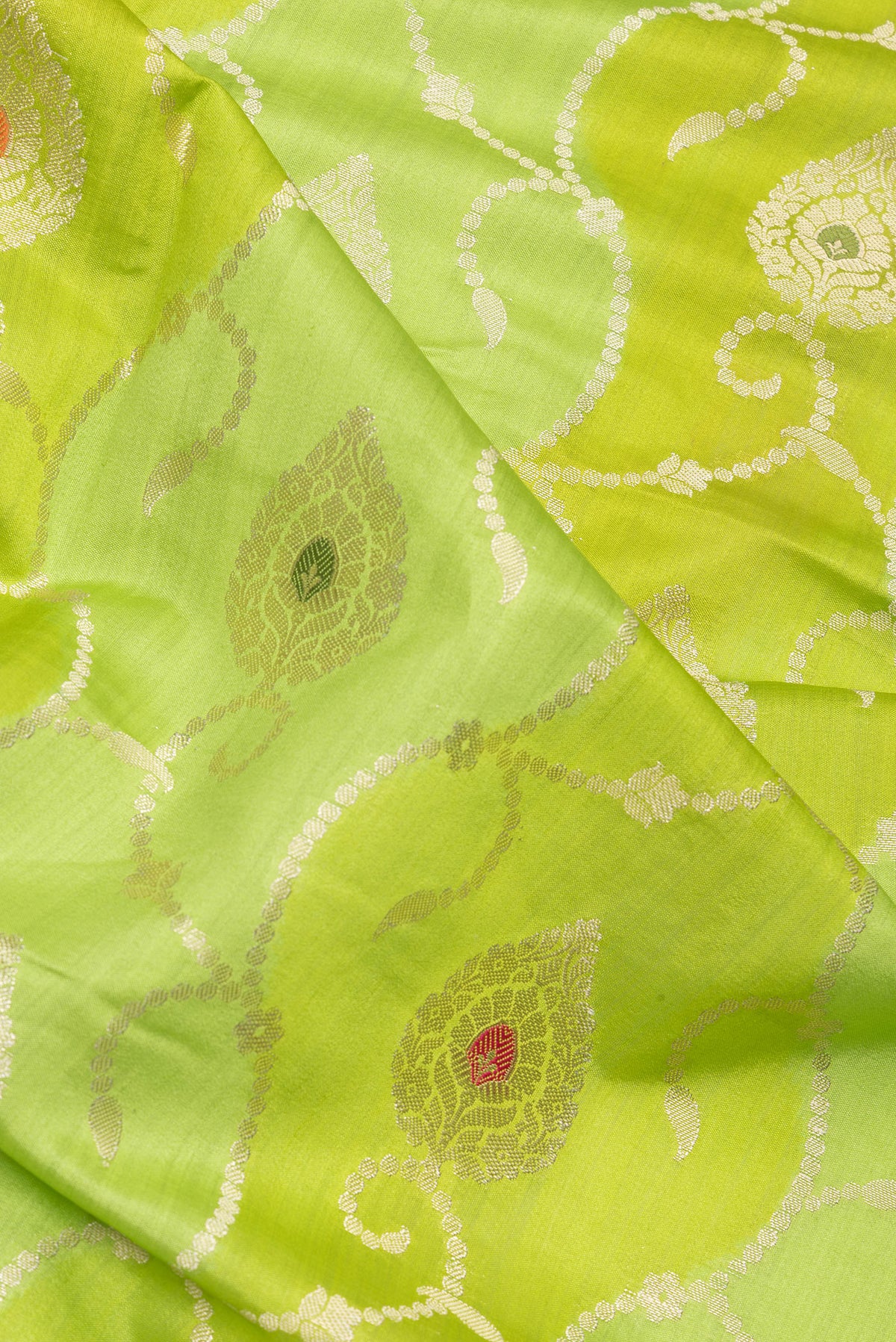 Close up of Parrot Green Dual Tone Tussar Silk Saree with Zari Brocade on the body and Zari Border.  displaying folds
