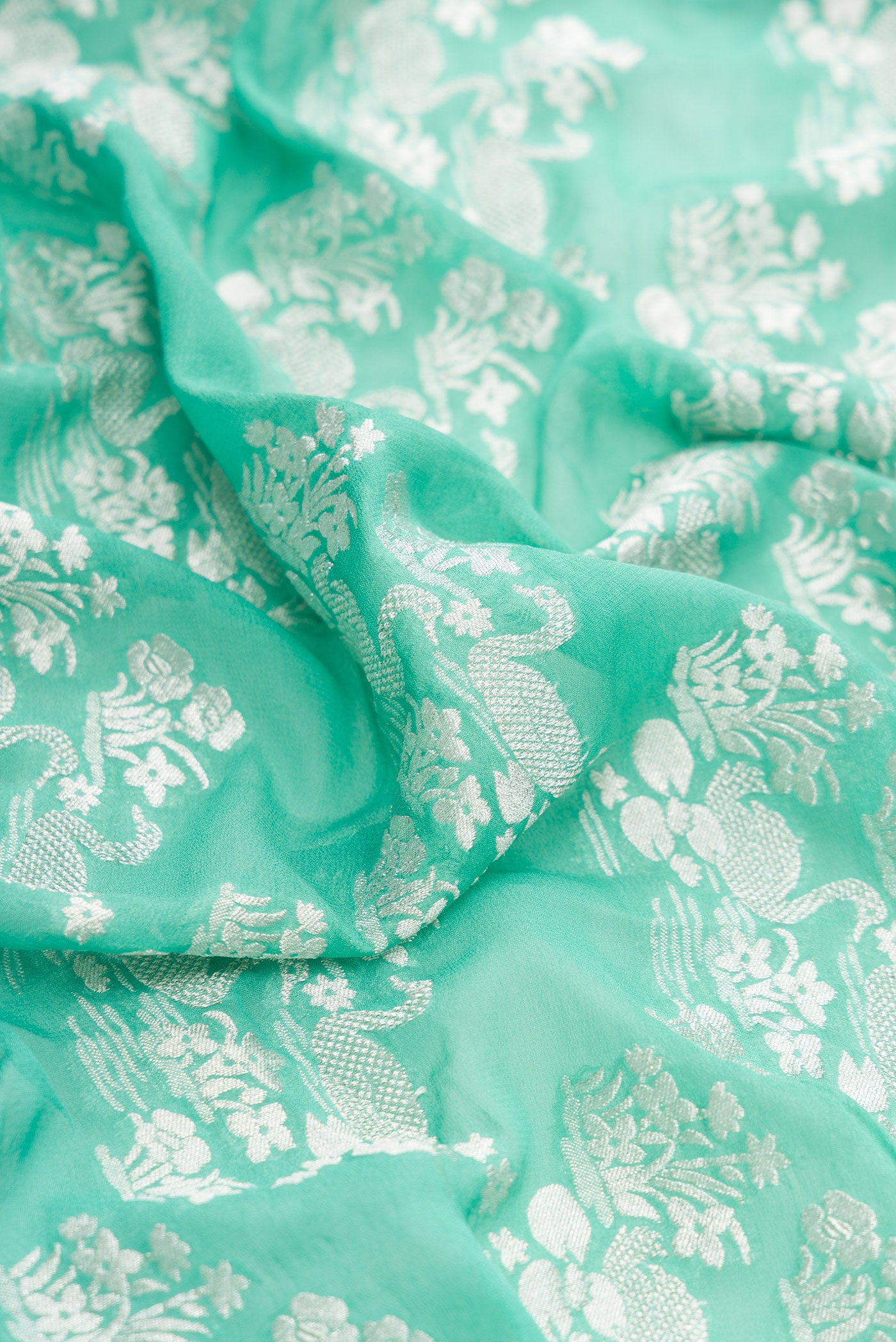 Close up of Sea Green Dual Tone Mysore Georgette Saree with Zari Brocade on the body and Zari Border.  displaying folds