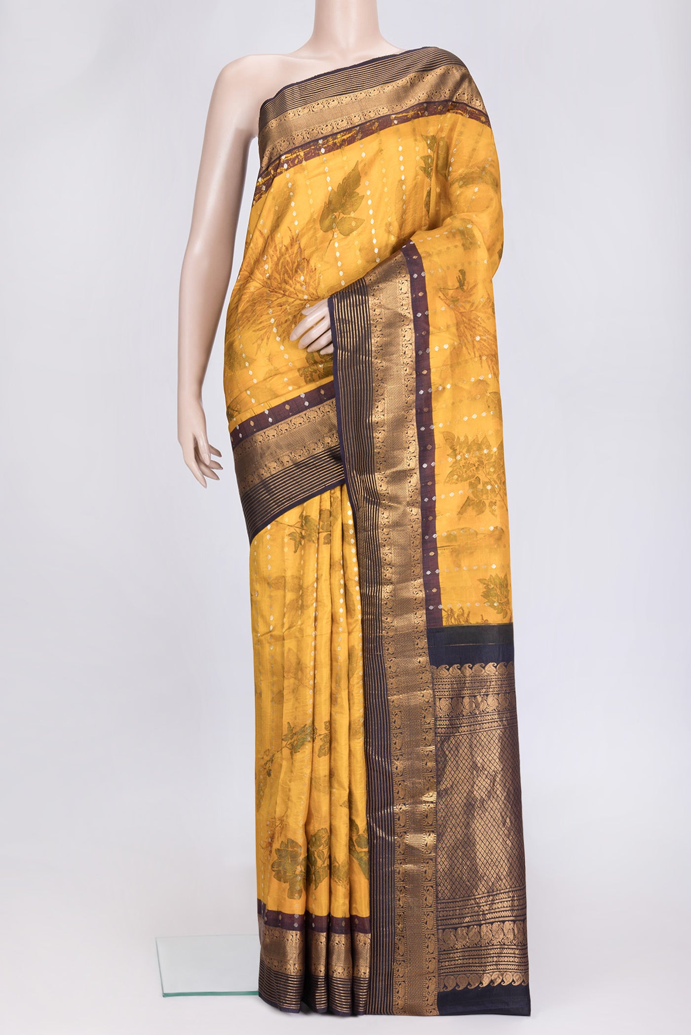 Mustard Dual Tone Kanchipuram Silk Saree with Printed design on the body and Zari Border.  displayed on a mannequin